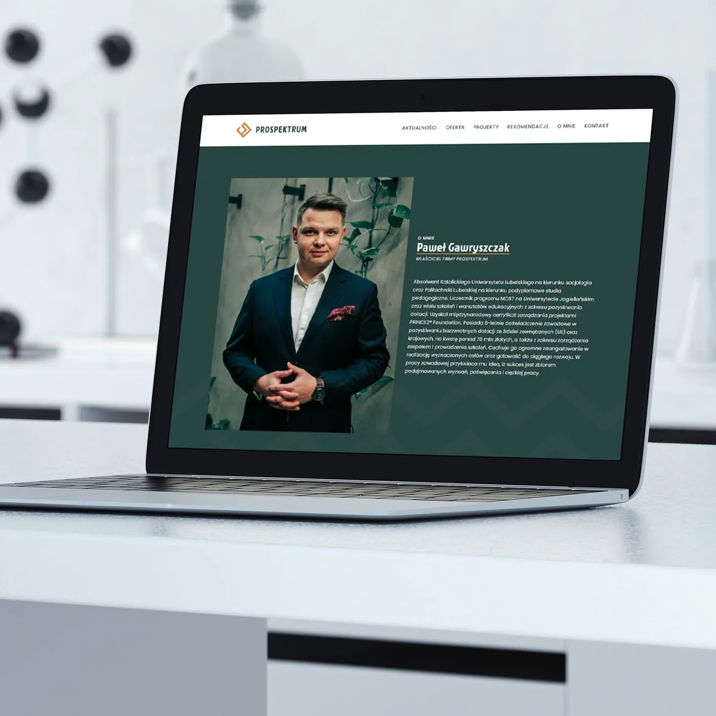 Prospektrum - makieta podstrony „o mnie" na laptopie, ze zdjęciem właściciela firmy i opisem jego wykształcenia oraz doświadczenia.