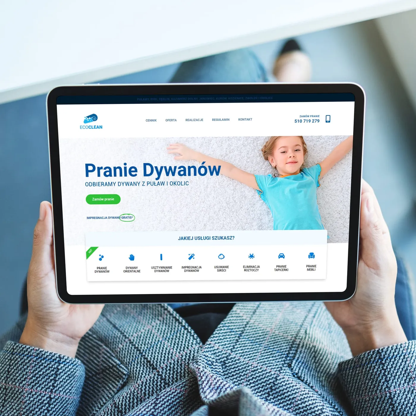 EcoClean - tablet trzymany w dłoniach z otwartą stroną główną „Pranie Dywanów" i przyciskiem „Zamów pranie".