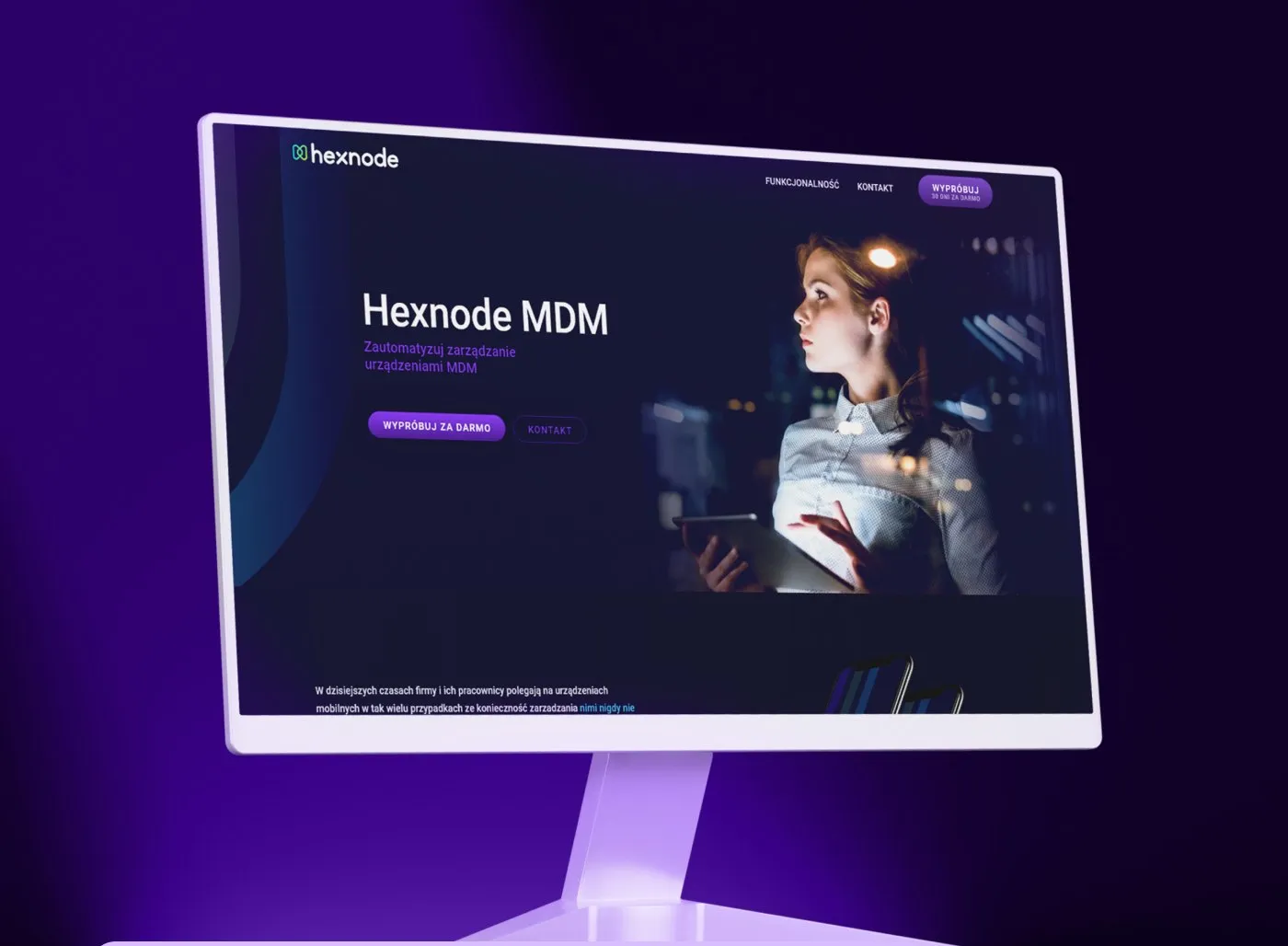 Hexnode MDM (DAGMA) - makieta strony na monitorze: hero „Hexnode MDM - zautomatyzuj zarządzanie urządzeniami” ze zdjęciem kobiety, na ciemnofioletowym tle.