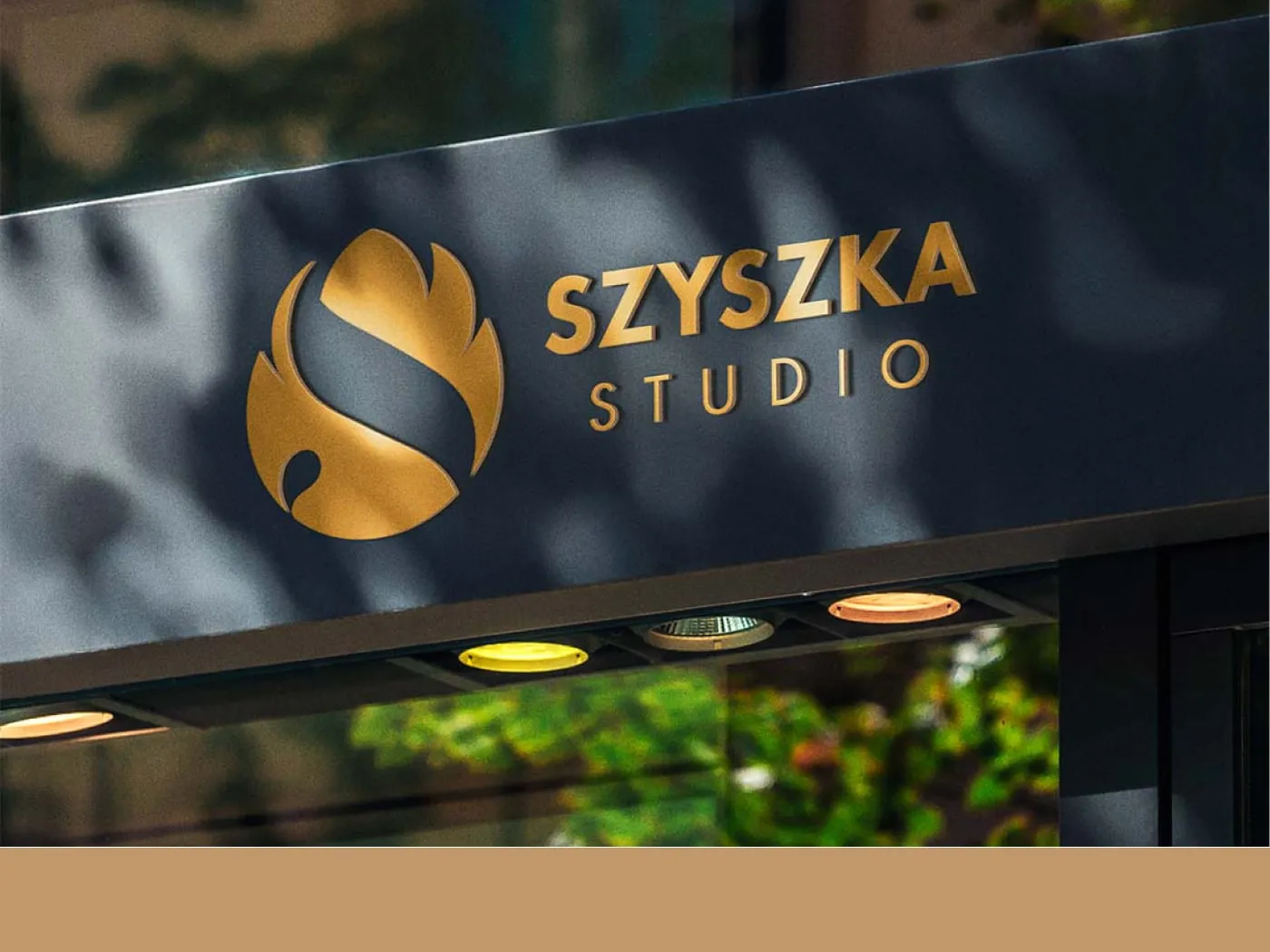 Szyszka Studio - złote logo (sygnet „S" w kształcie szyszki) na podświetlanym szyldzie ciemnej witryny studia.