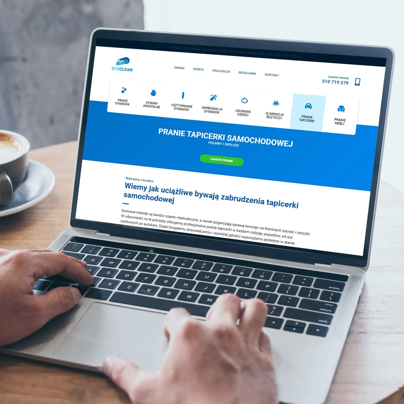 EcoClean - laptop z podstroną „Pranie Tapicerki Samochodowej", nagłówkiem na niebieskim tle i przyciskiem zamówienia.