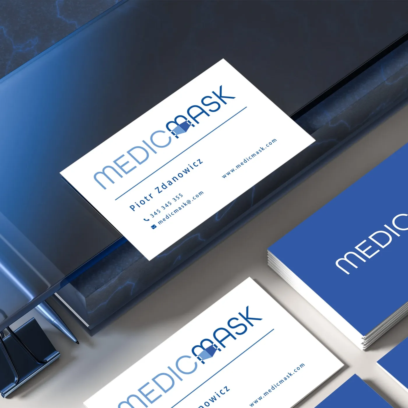 MedicMask - wizytówki firmowe w wersji białej i granatowej, z logotypem i danymi kontaktowymi, na ciemnym tle.